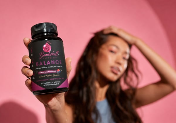 A hand holding a bottle of Bombshell Balance