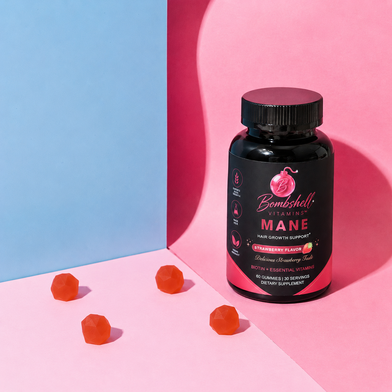 Bottle of Bombshell Mane beside four gummies on a pink and blue background